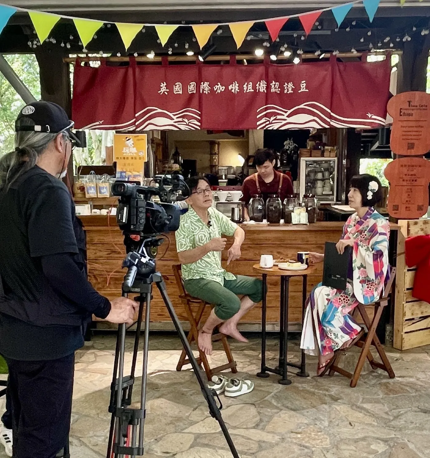礁溪一館吧台,紅色門簾寫著英國國際咖啡組織認證豆,媒體正在採訪拍攝